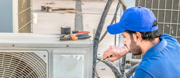 Passion Heating & Air technician servicing AC unit in West Ashley backyard